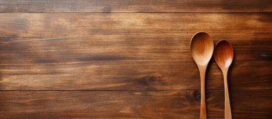 A wooden dish with a wooden spoon and fork is shown with a copy space image on a wooden plank 102 characters