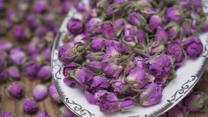Purple dried rose flower in white bowl
