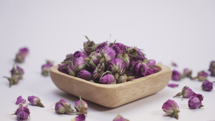 Purple dried rose flower on white background