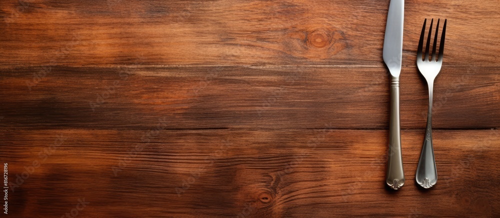 Poster A wooden texture background with a white plate fork and knife leaving copy space in the image