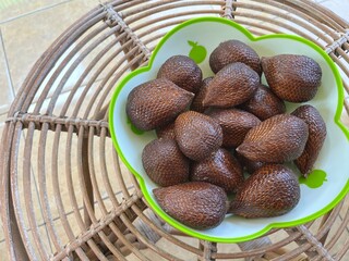 Several Indonesian Salak Fruit or snake fruit in a plastic bowl