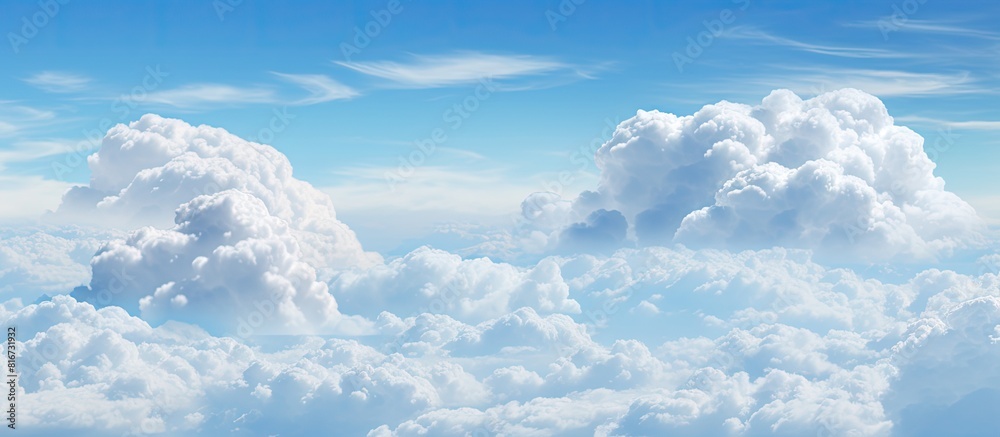 Poster The spacious blue sky is adorned with large billowing white clouds creating an ideal copy space for adding text