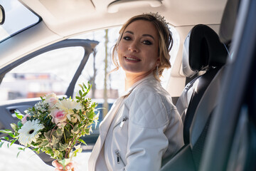Portrait of a bride with a wedding bouquet in her hands, a girl sitting in a car