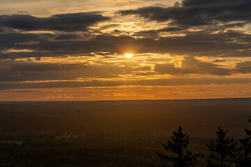 Scenic landscape of a sunset sky over the lush trees of Nolberget, Sweden