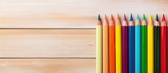 Obraz premium On a wooden board there is an empty notebook accompanied by a multicolored pencil The image offers copy space