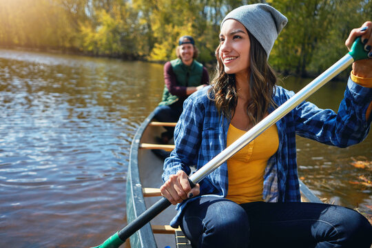 Couple, canoe and lake rowing for nature holiday or exploring outdoor, environment or journey. Man, woman and happy or travel weekend on island river at camp for vacation in Colorado, calm or forest