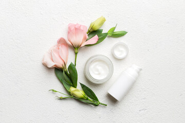 Composition with cosmetic products and beautiful roses on cement background. Flat lay