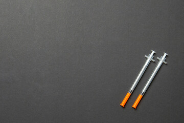 Top view of two insulin syringe at colorful background with copy space. High level of glucose concept