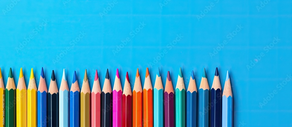 Aufkleber top view of color pencils on a blue background with plenty of copy space image
