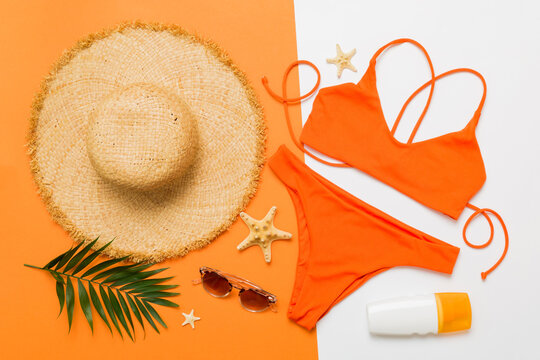 Woman swimwear and beach accessories flat lay top view. Top view with bikini outfit on color background. Vacation concept copy space