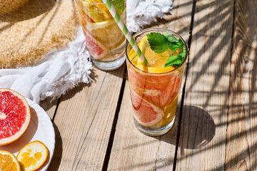 Summer refreshing lemonade drink with grapefruit, lemon, orange slices and mint. Fresh healthy cold citrus beverage. Citrus fruit infused water.