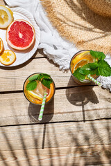 Summer refreshing lemonade drink with grapefruit, lemon, orange slices and mint. Fresh healthy cold citrus beverage. Citrus fruit infused water.