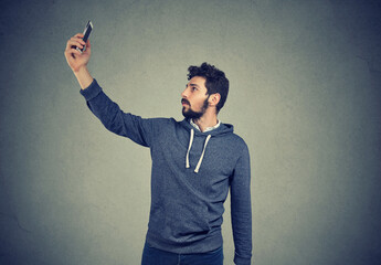 Bad wifi connection, man, lifts mobile phone up and wants to connect to internet. 