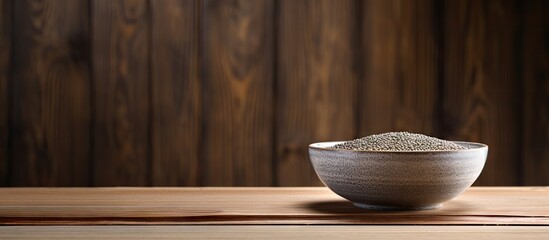 A wooden table holds a bowl of nutritious Chia seeds capturing an appealing copy space image