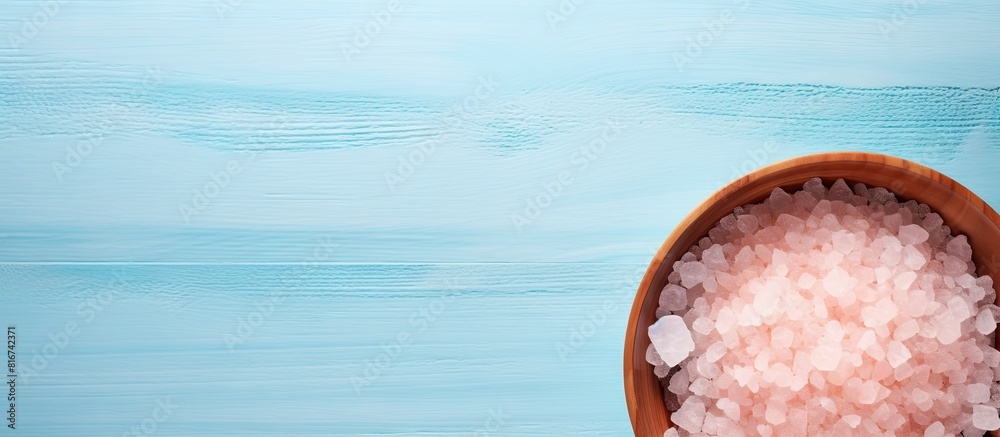 Poster top down flat lay image of a pink himalayan salt plate on a pastel blue background with ample space 