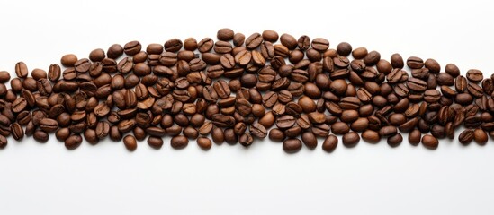 A copy space image of brown coffee beans arranged in the shape of a Christmas tree on a white background