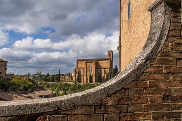 Picturesque view of the historic Siena church against a cloudy sky.