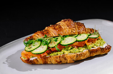 Gourmet salmon avocado croissant sandwich