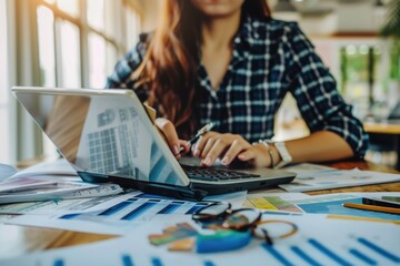 Woman sitting at a table using a laptop. Suitable for technology and business concepts