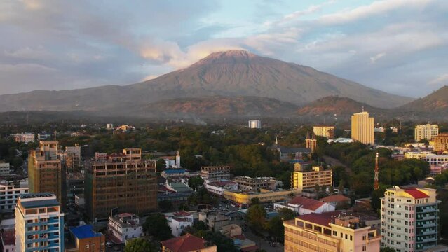 Drone footage of the urban buildings of Arusha city with Mount Meru in the background in Tanzania