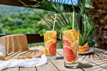 Summer refreshing lemonade drink with grapefruit, lemon, orange slices and mint. Fresh healthy cold citrus beverage. Citrus fruit infused water.