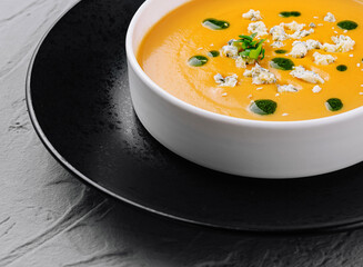 Creamy pumpkin soup in elegant white bowl