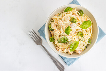 Creamy Chicken Spaghetti with Broccoli in a Bowl Garnished with Fresh Basil Leaves Top Down Photo