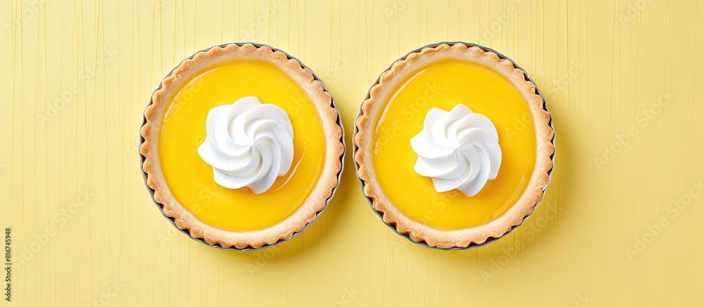 Poster top view of two beautifully decorated lemon curd tarts with plenty of copy space image