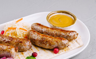 Grilled sausages with sauerkraut and mustard on plate