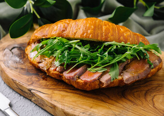 Gourmet croissant sandwich with arugula and ham