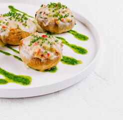 Gourmet stuffed mushrooms on plate with pesto drizzle