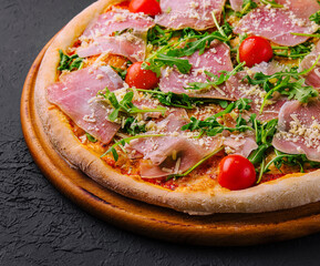 Gourmet italian pizza with prosciutto and arugula