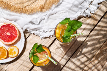 Summer refreshing lemonade drink with grapefruit, lemon, orange slices and mint. Fresh healthy cold citrus beverage. Citrus fruit infused water.