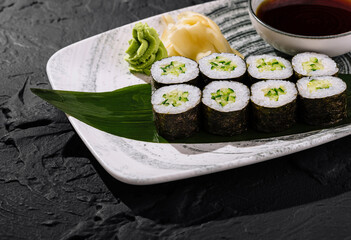 Fresh avocado sushi roll on slate background