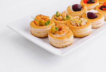 Gourmet assorted mini tartlets on white plate