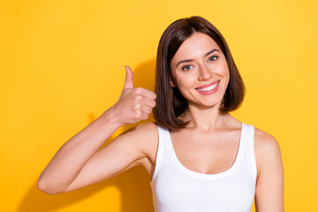 Photo portrait of attractive young girl thumb up wear trendy white outfit isolated on yellow color...