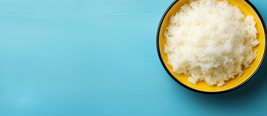 Top view of a bowl of boiled rice on a colorful background providing ample space for text in the...