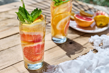Summer refreshing lemonade drink with grapefruit, lemon, orange slices and mint. Fresh healthy cold citrus beverage. Citrus fruit infused water.