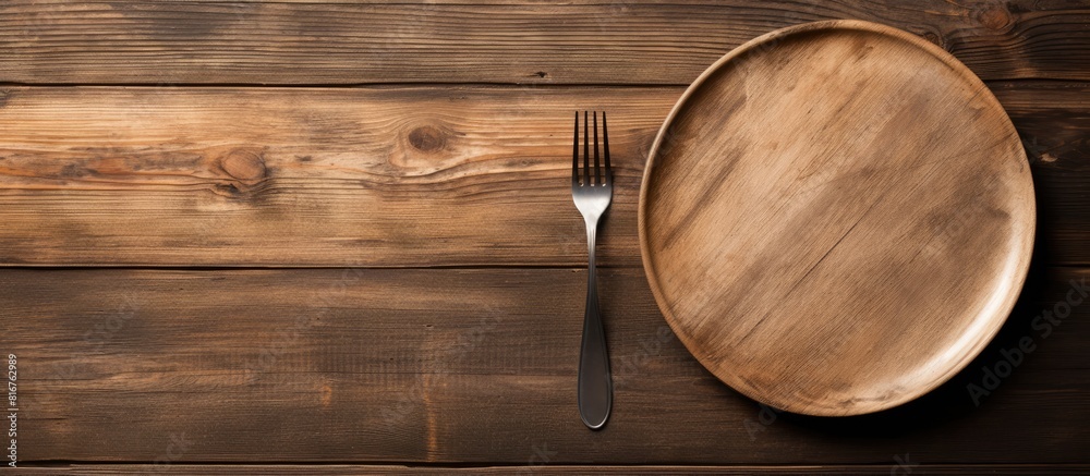 Poster empty plate with silver fork and knife on wooden background. copy space available