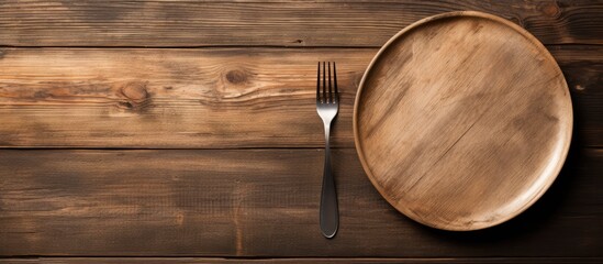Empty plate with silver fork and knife on wooden background. copy space available