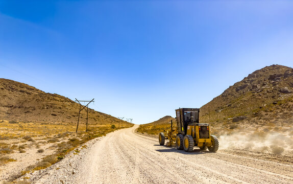 Richtersveld, South Africa - March 12, 2024: Caterpillar gravel dirt road grader smoothing out a road surface