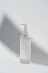 Blank label on product bottle in shadow on white background