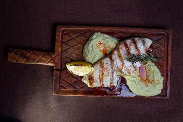 top view of the Grilled fish fillet with lemon and herb butter on a wooden board
