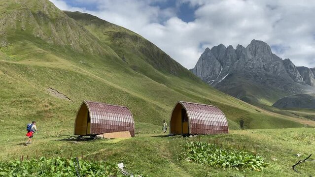 Hikers walking on a hiking trails near wooden cabins in Juta Village, Georgia