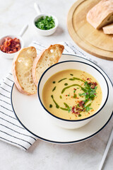 Bowl of potato soup with parsley and bacon with toasted bread croutons in white bowl. Comfort meal