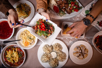 A table with delicious Uzbek dishes like soup, salad, dumplings, and meat skewers, offering a taste of Uzbekistans culinary heritage.