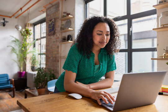 Young adult female working from home in a loft apartment on her startup business
