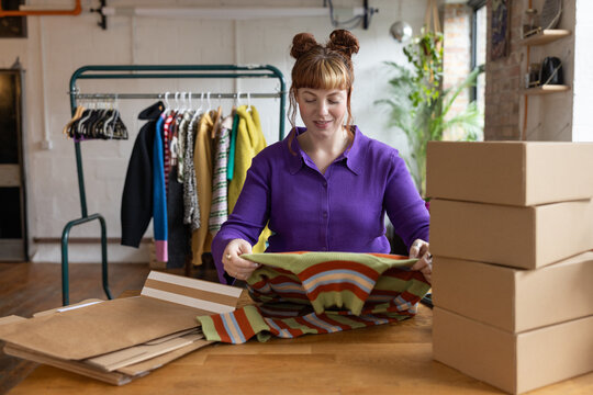 Young female vintage fashion business owner packing orders