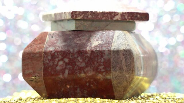 Closeup of a human ashes stone urn or sarcophagus (Stone Coffin) with blur glittery background