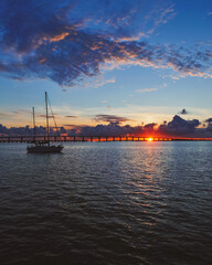 Sailboat silhouetted against a stunning backdrop of a brilliant sunset on the horizon